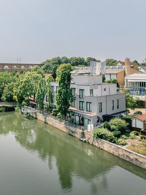 Eberhards am Wasser direkt am Fluss mit historischem Viadukt im Hintergrund.
