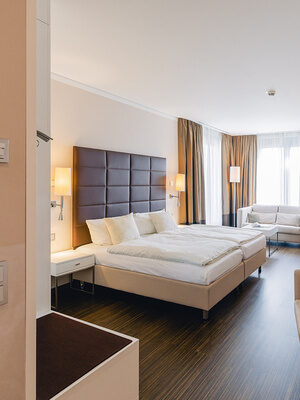 Helles Doppelzimmer mit großem Bett, Sitzecke und moderner Einrichtung